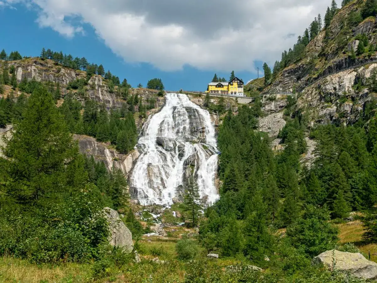Cascata imponente con hotel giallo in cima, ideale per escursioni tra le migliori cascate.