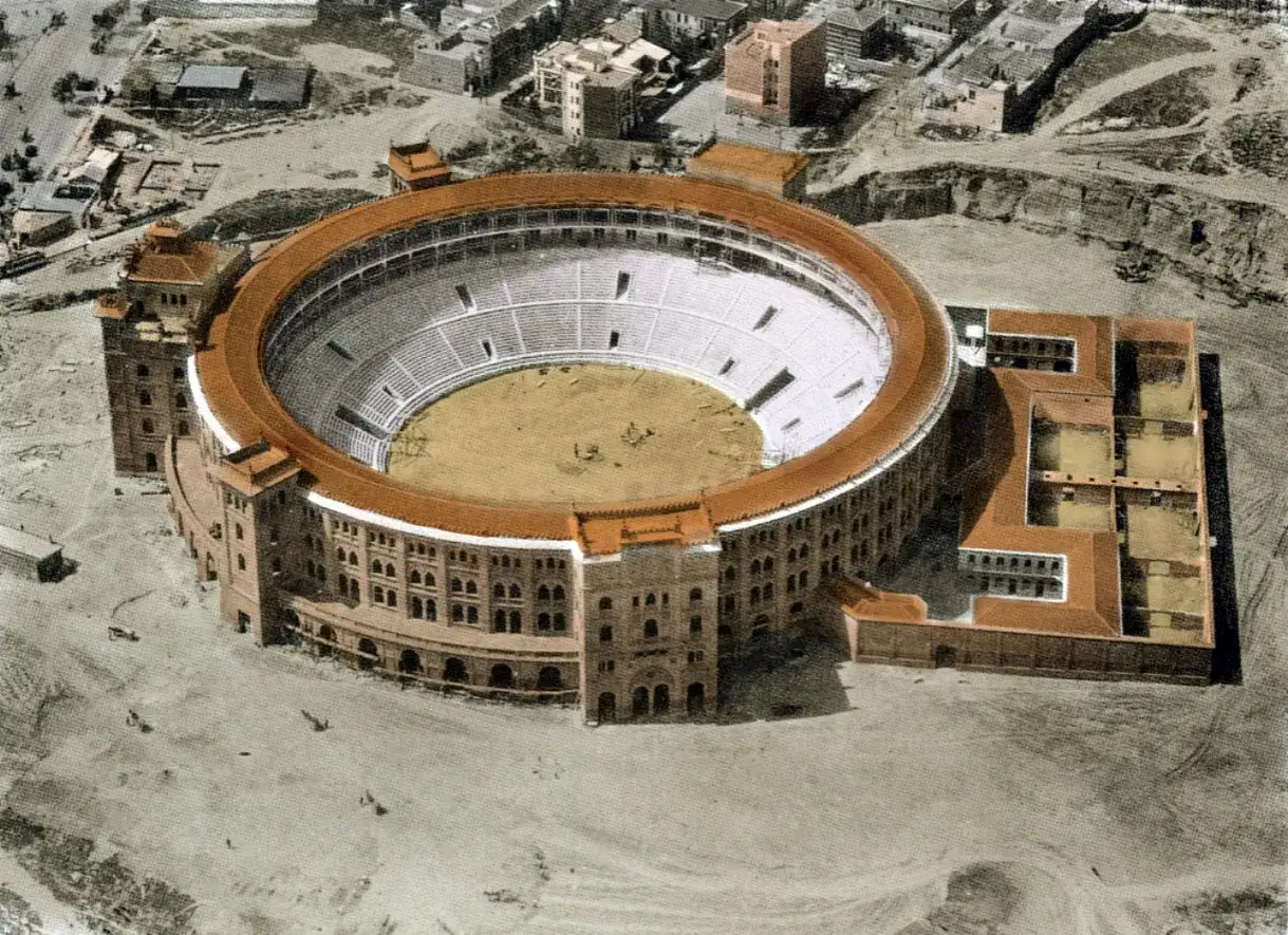 Vista a&eacute;rea de la antigua plaza de toros de Madrid, con su ruedo circular y gradas, rodeada de edificios y un paisaje &aacute;rido.