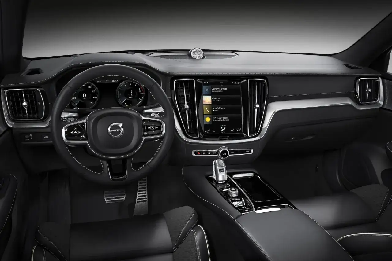 Wnętrze Volvo S60 z ekranem dotykowym, cyfrowymi zegarami i kierownicą. Zastanawiasz się, jaki silnik wybrać do swojego Volvo S60?