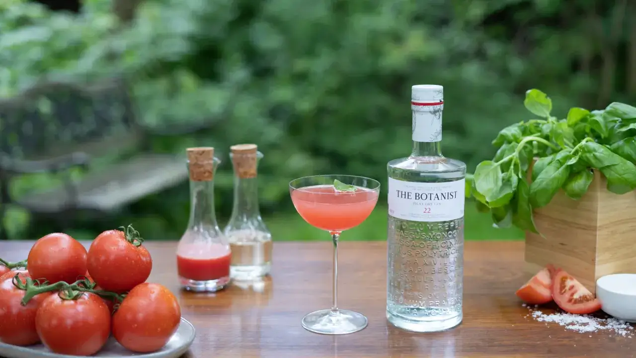 Orzeźwiający drink z sokiem pomidorowym, ginem The Botanist i świeżą bazylią, gotowy do degustacji w ogrodzie.