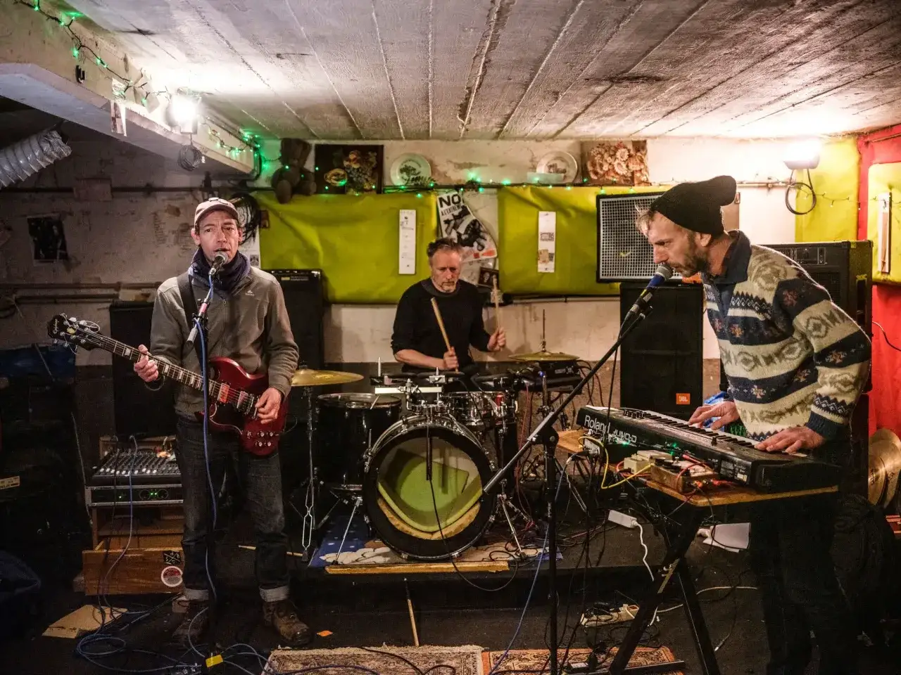 Un groupe de musique punk français, le meilleur, en pleine action. Un guitariste, un batteur et un claviériste sur scène.