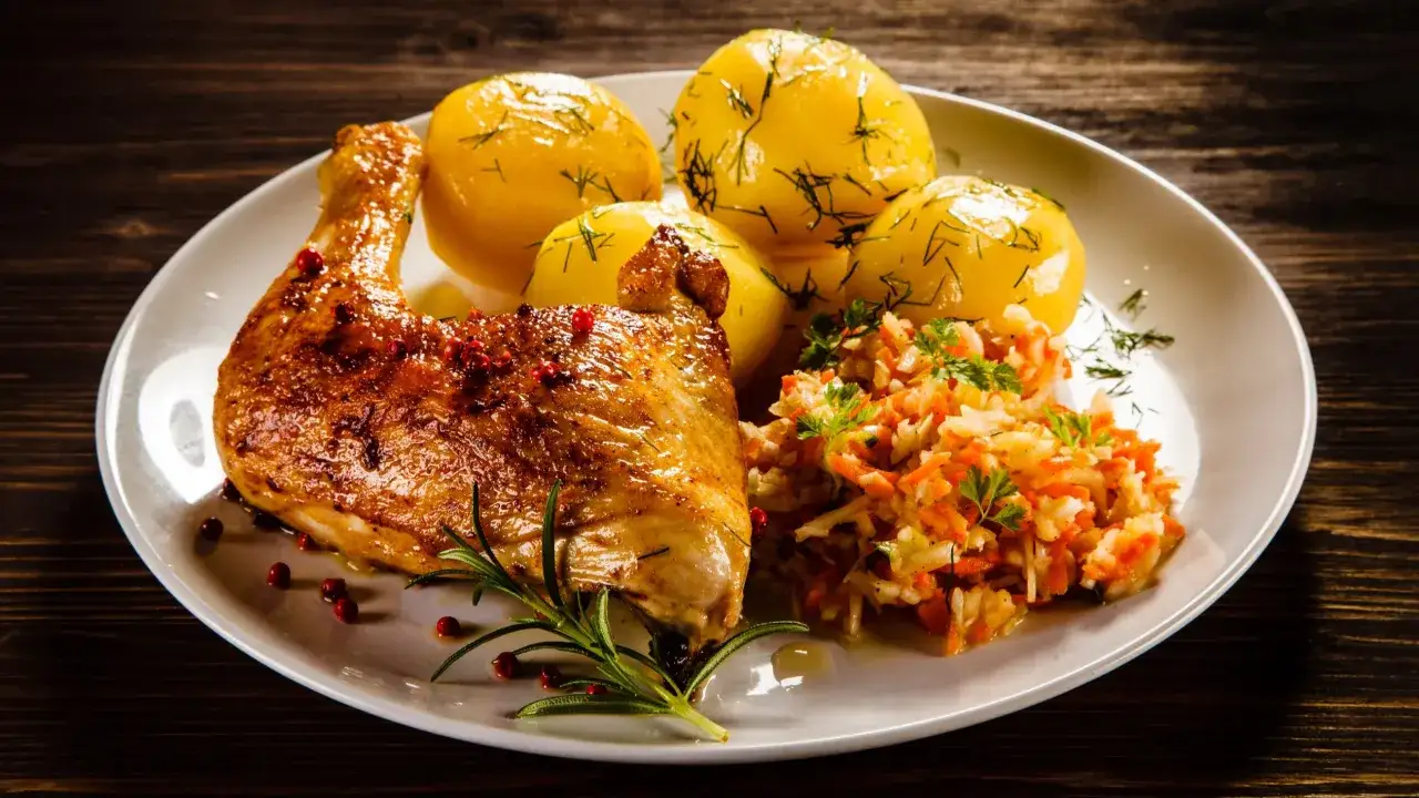 Pieczony kurczak z ziemniakami i surówką. Idealna porcja mięsa na obiad, ok. 200 gramów na osobę, by nasycić się smakiem.