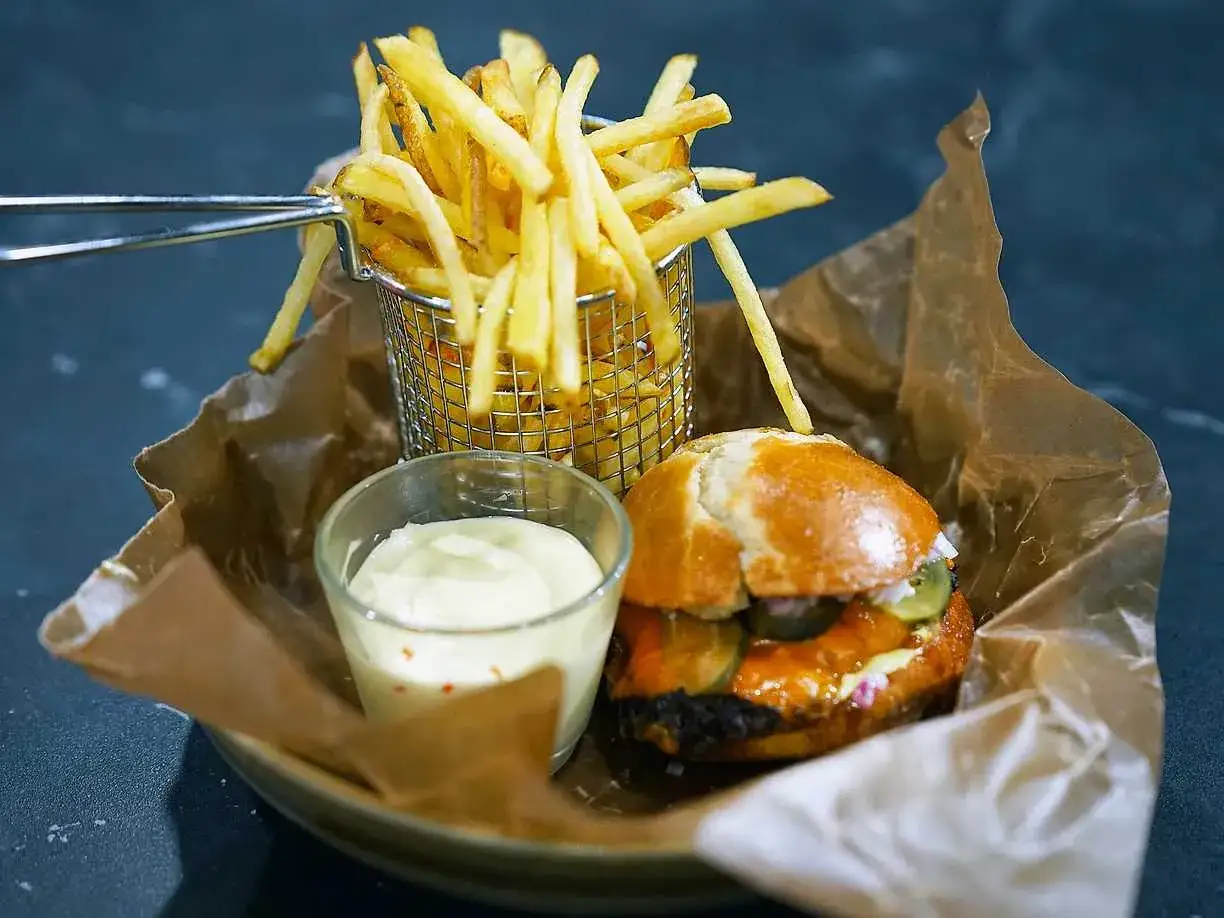 En saftig burgare med krispiga pommes frites och en skål med krämig sriracha mayo. Perfekt för en snabb och god måltid.