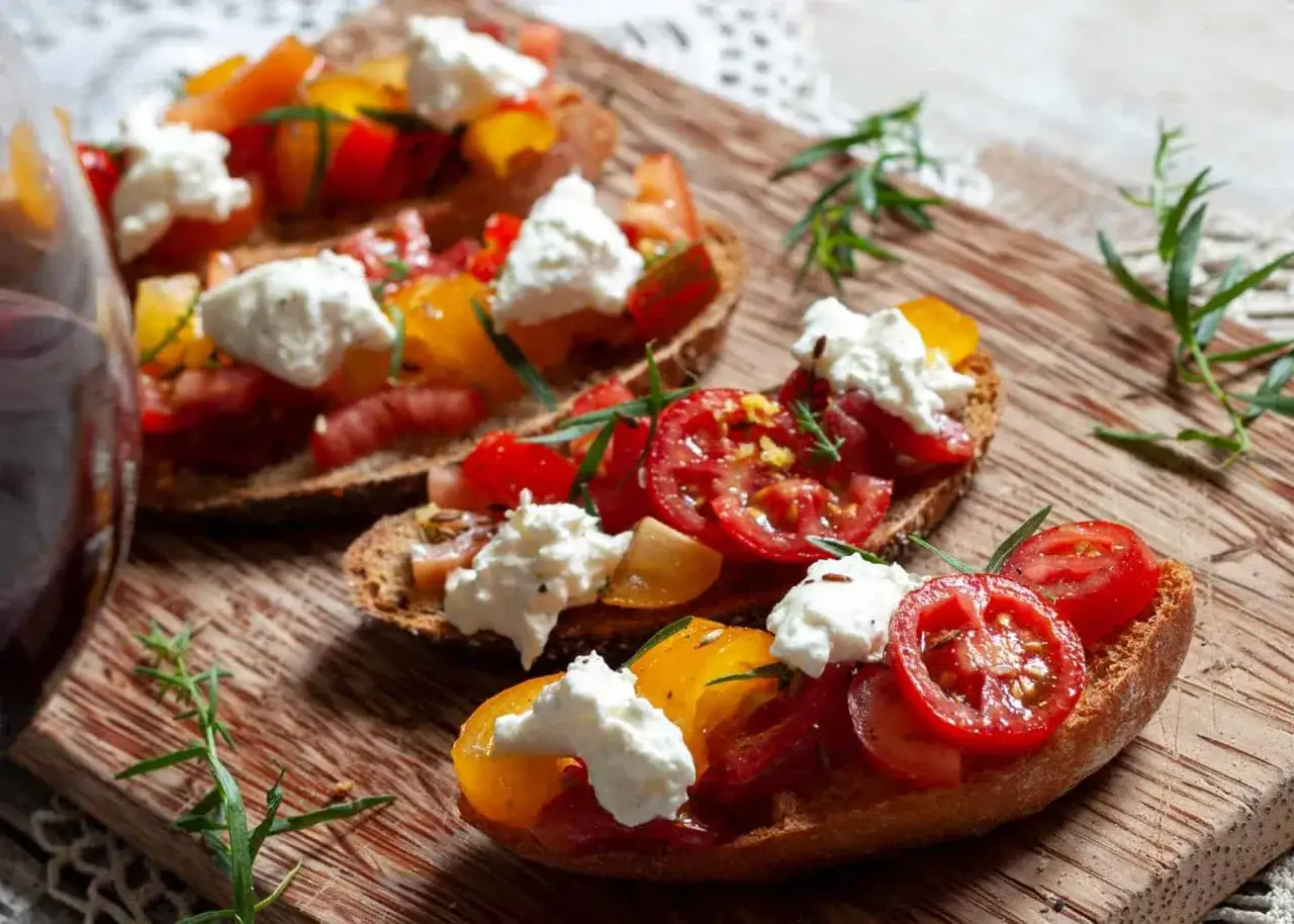 Leckere Bruschetta mit bunten Tomaten und cremiger Burrata. Perfekt für leichte Sommergerichte und Burrata Rezepte.