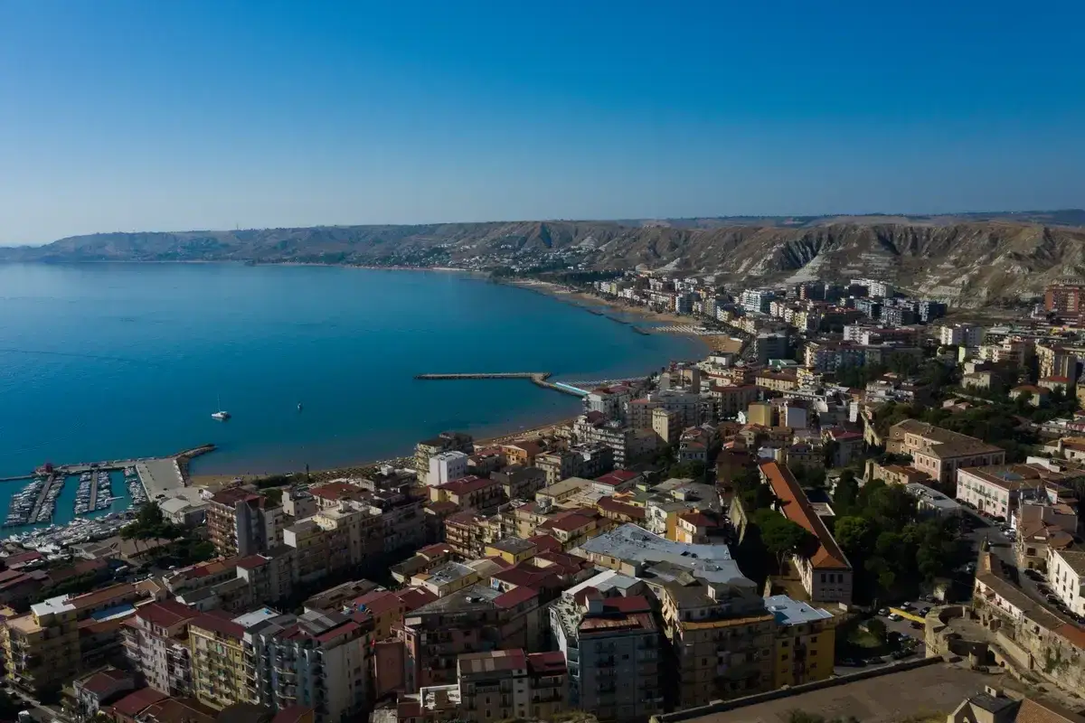 Crotone cosa vedere: vista aerea della costa con il porto, le spiagge e la città che si estende verso le colline.