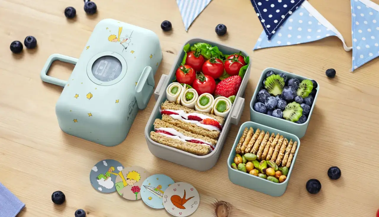 Inspirujące lunchbox do pracy przepisy: kanapka z truskawkami, rolki z warzywami, pomidorki, jagody, kiwi i orzeszki.