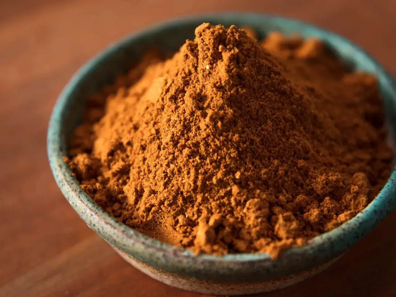 En sk&aring;l med gyllene masala krydda, redo att f&ouml;rh&ouml;ja smaken p&aring; din matlagning.
