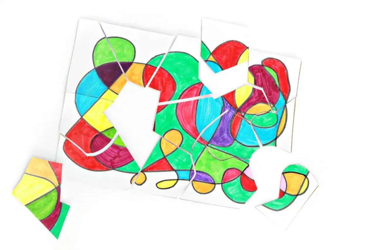 Bunte Formen, die zum **Puzzle basteln** einladen. Einzelne Teile liegen verstreut, das Bild ist noch nicht komplett.