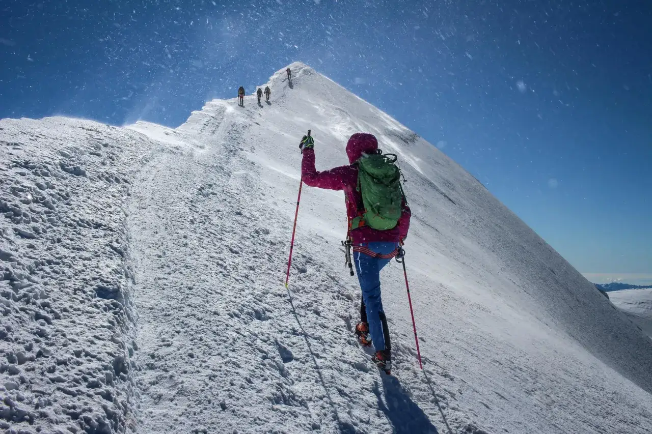 Bergsteiger auf dem Mont Blanc Normalweg, kämpfen sich durch Schnee und Wind dem Gipfel entgegen.