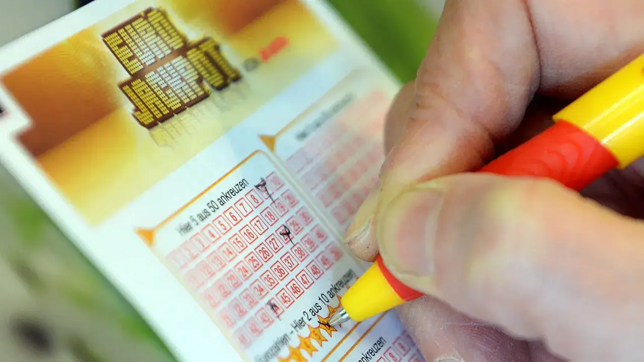 Prawda o rzekomych wróżbitach którzy trafili liczby w eurojackpot. Dłoń z długopisem zaznacza liczby na kuponie lotto.
