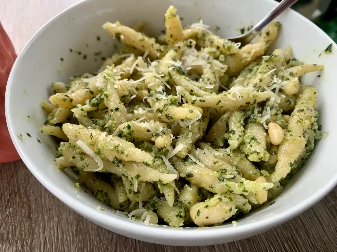 Eine Sch&uuml;ssel mit ligurischer Pasta, bedeckt mit leuchtend gr&uuml;nem Pesto, Pinienkernen und geriebenem Parmesan.