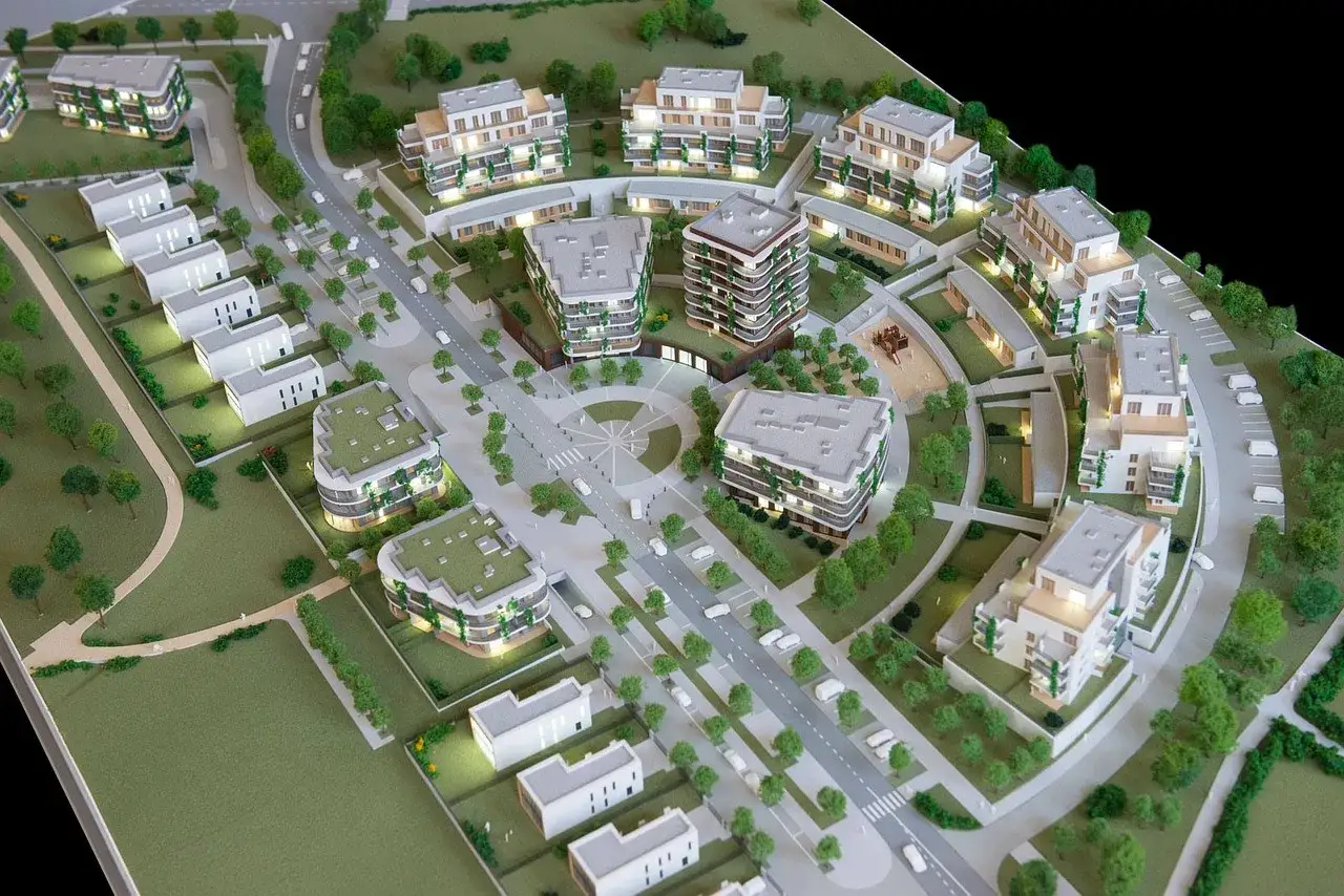 Model osiedla z budynkami mieszkalnymi i domami jednorodzinnymi. Pokazuje, od czego zacząć budowę domu, planując przestrzeń.