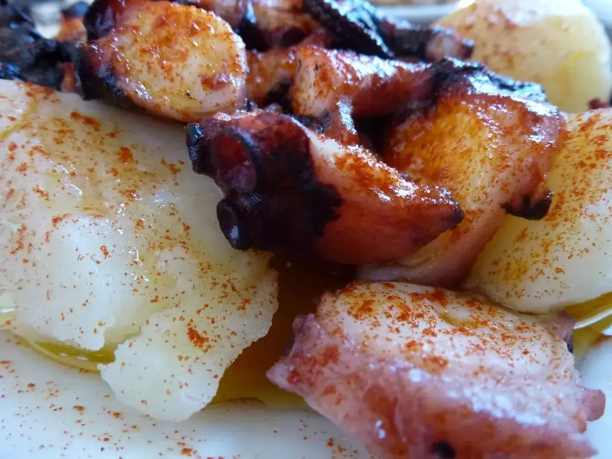 Pulpo con cachelos, un plato gallego con trozos de pulpo tierno y patatas cocidas, espolvoreado con piment&oacute;n y aceite de oliva.