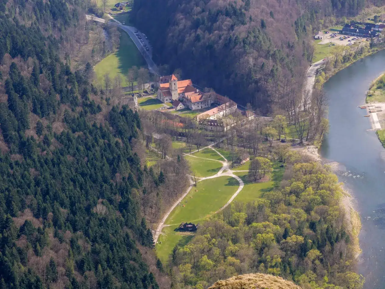 Widok z lotu ptaka na Czerwony Klasztor w Pieninach, otoczony lasami i rzeką Dunajec.
