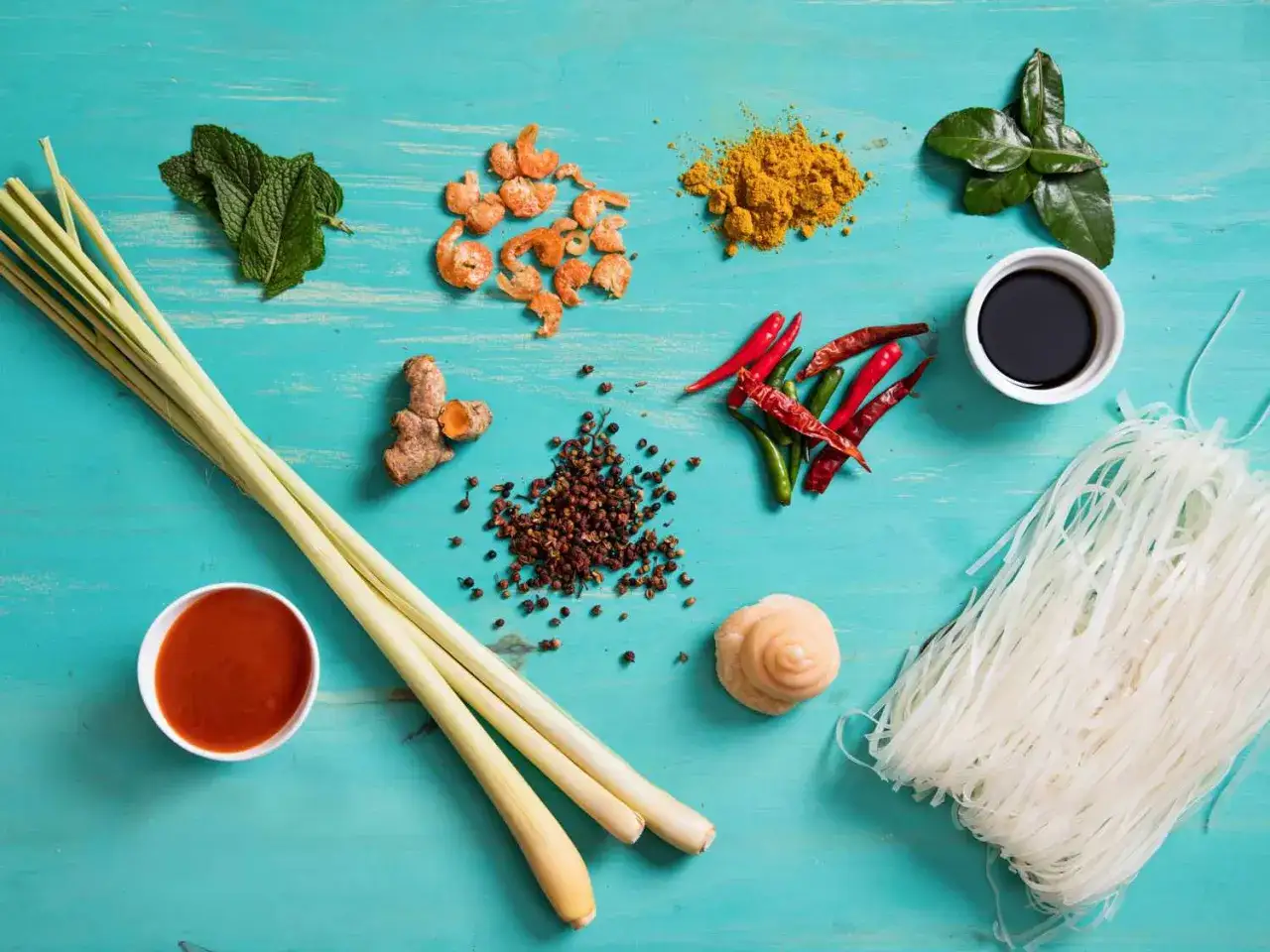Składniki do sosu pad thai: trawa cytrynowa, imbir, chili, krewetki, liście limonki, przyprawy, makaron ryżowy i sos sojowy.