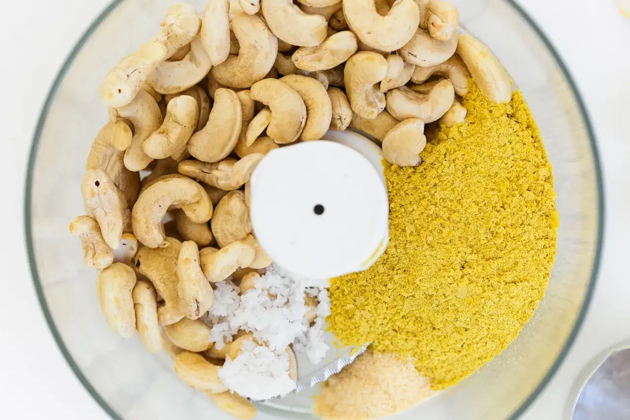 Zutaten für veganen Parmesan selber machen: Cashewkerne, Hefeflocken, Salz und Knoblauchpulver im Mixer.