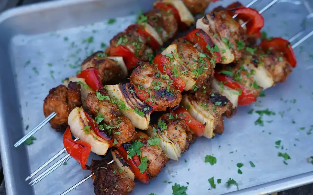 Fertige Schaschlik-Spie&szlig;e mit Fleisch, Paprika und Zwiebeln, garniert mit Petersilie. Ein tolles Schaschlik Rezept f&uuml;r den Grill.