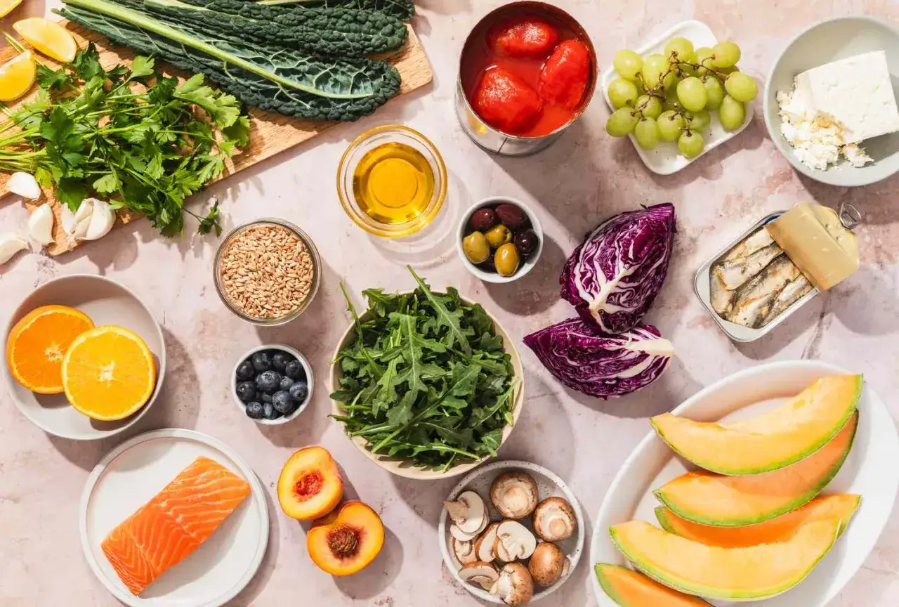 Scopri quali sono i superfood: salmone, mirtilli, cavolo nero, arance, olio d'oliva, sardine, uva, pomodori, cavolo rosso, rucola, pesche, funghi, olive e semi.