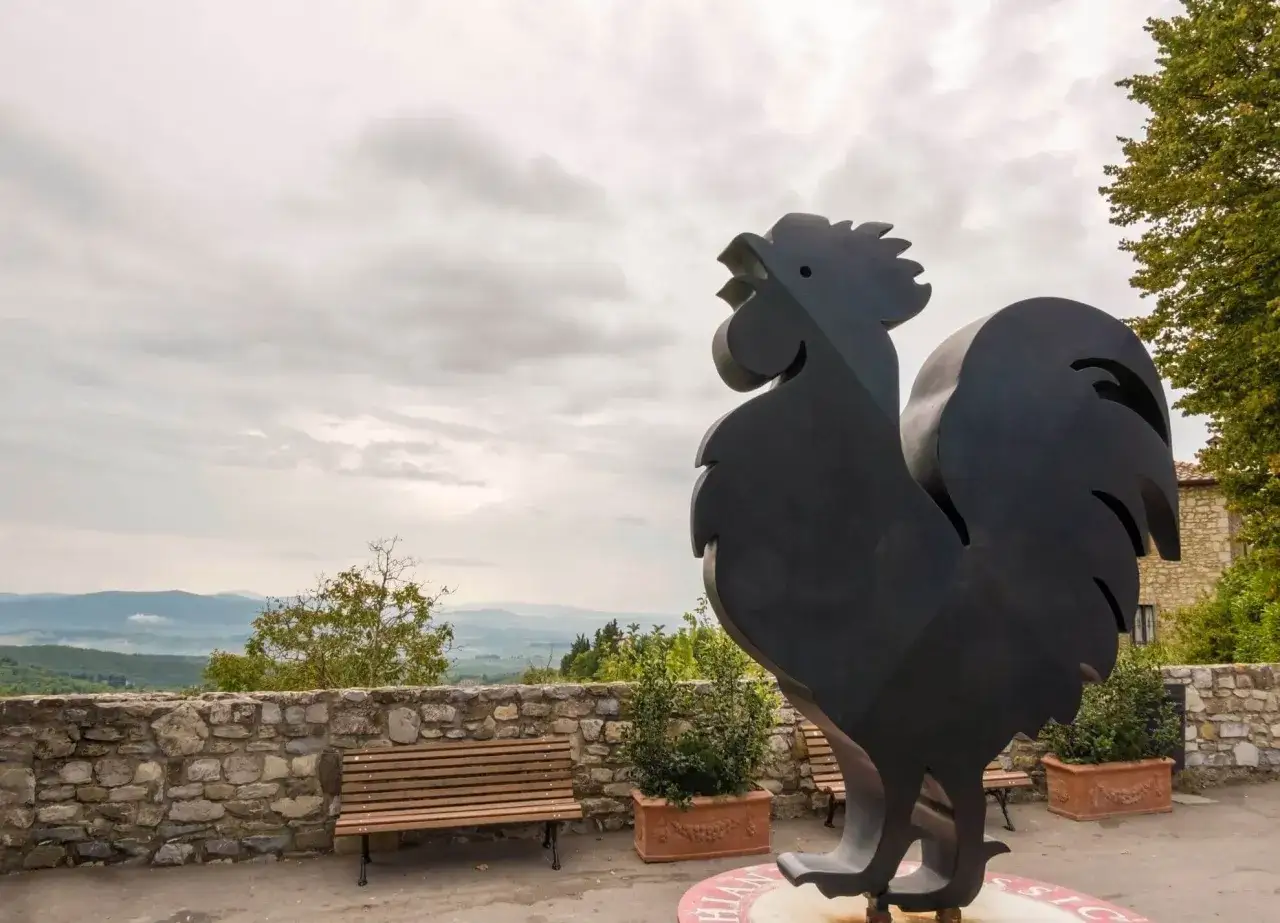 Scultura del gallo nero, simbolo del miglior Chianti, domina il paesaggio collinare toscano.