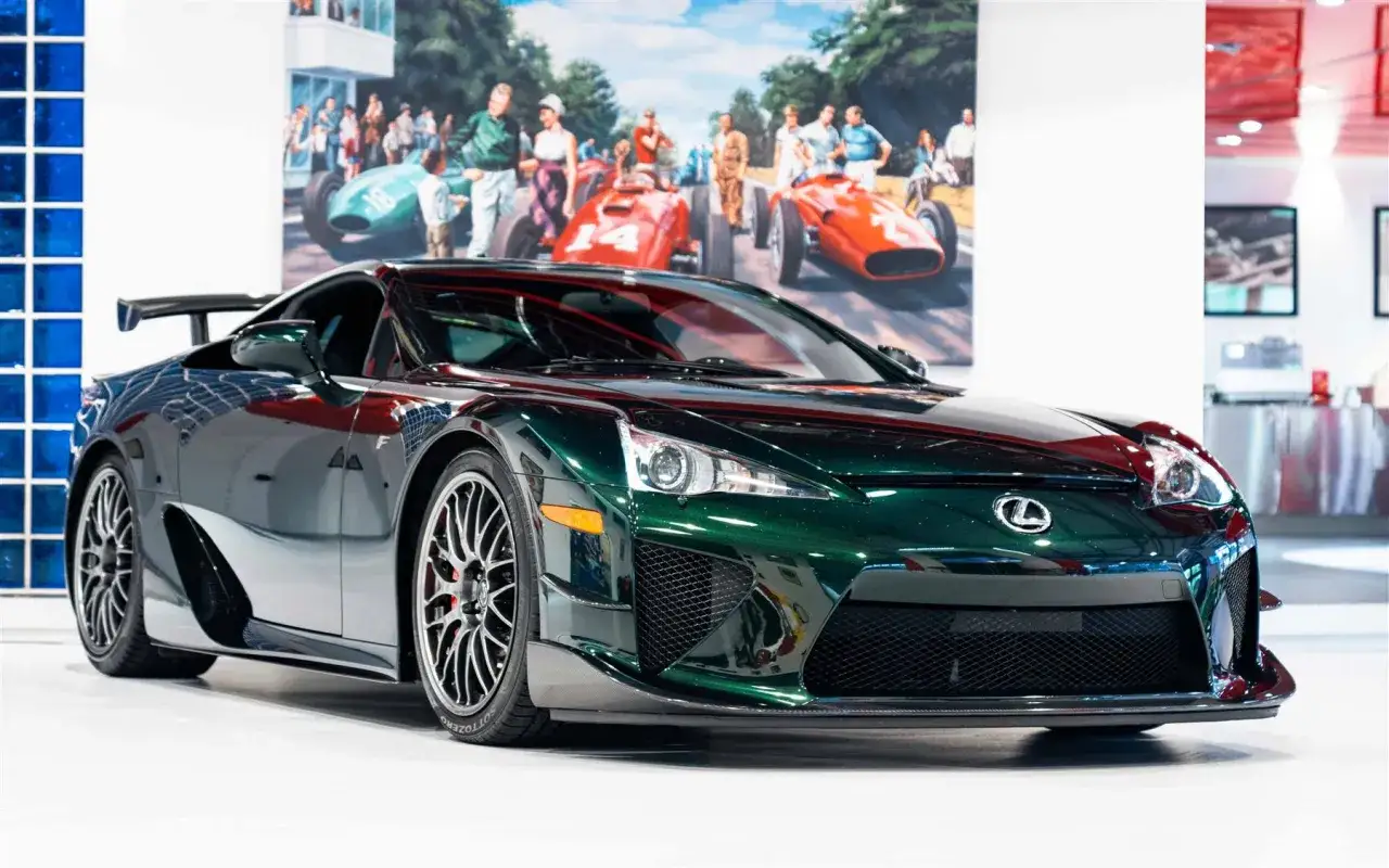 Lexus LFA w kolorze głębokiej zieleni, z imponującym malowidłem wyścigowym w tle. Marzenie o tym aucie, jego lexus lfa cena, jest w zasięgu ręki.