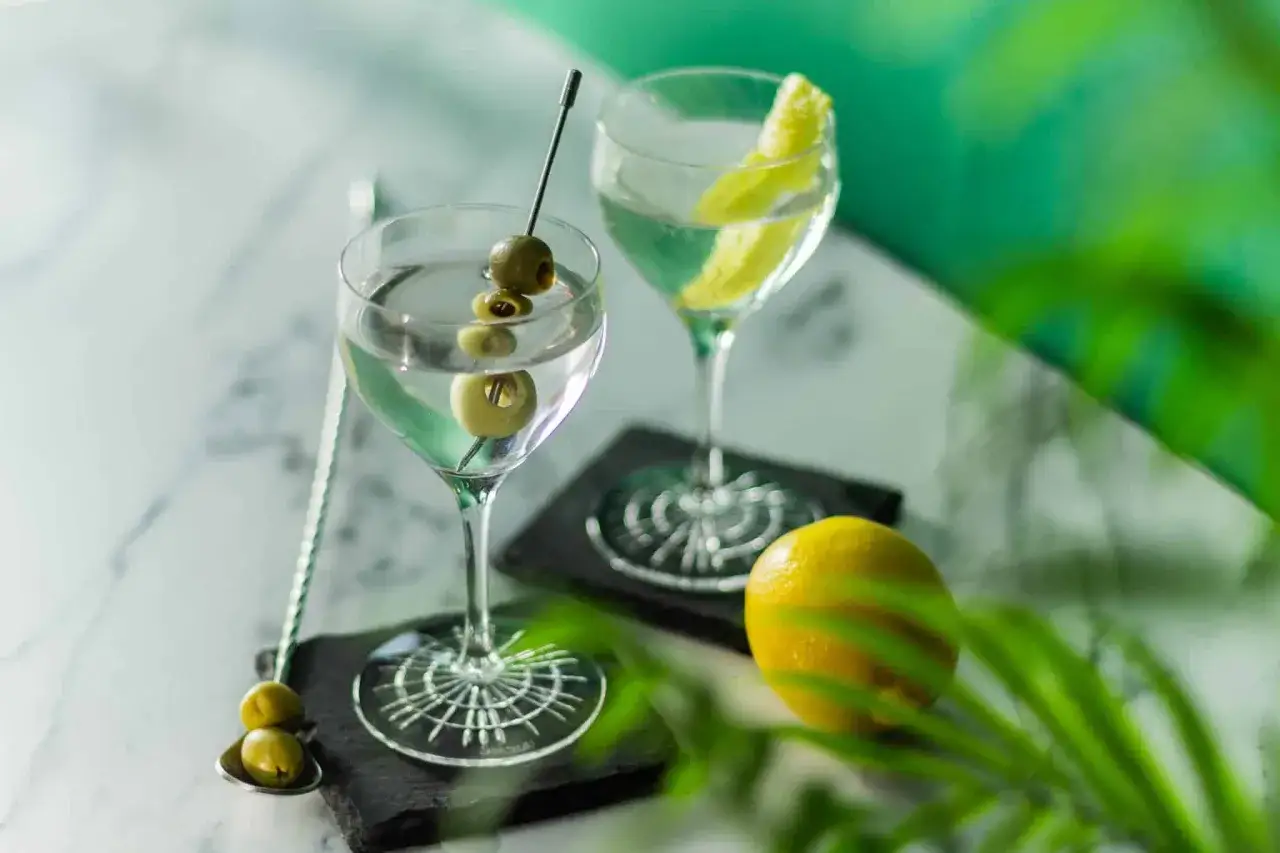 Deux vodkas martini, l'une garnie d'olives, l'autre d'un zeste de citron. Une recette classique pour un apéritif chic.