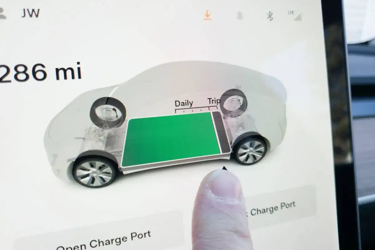Schermo Tesla Model Y: 286 miglia di autonomia, batteria verde visibile.