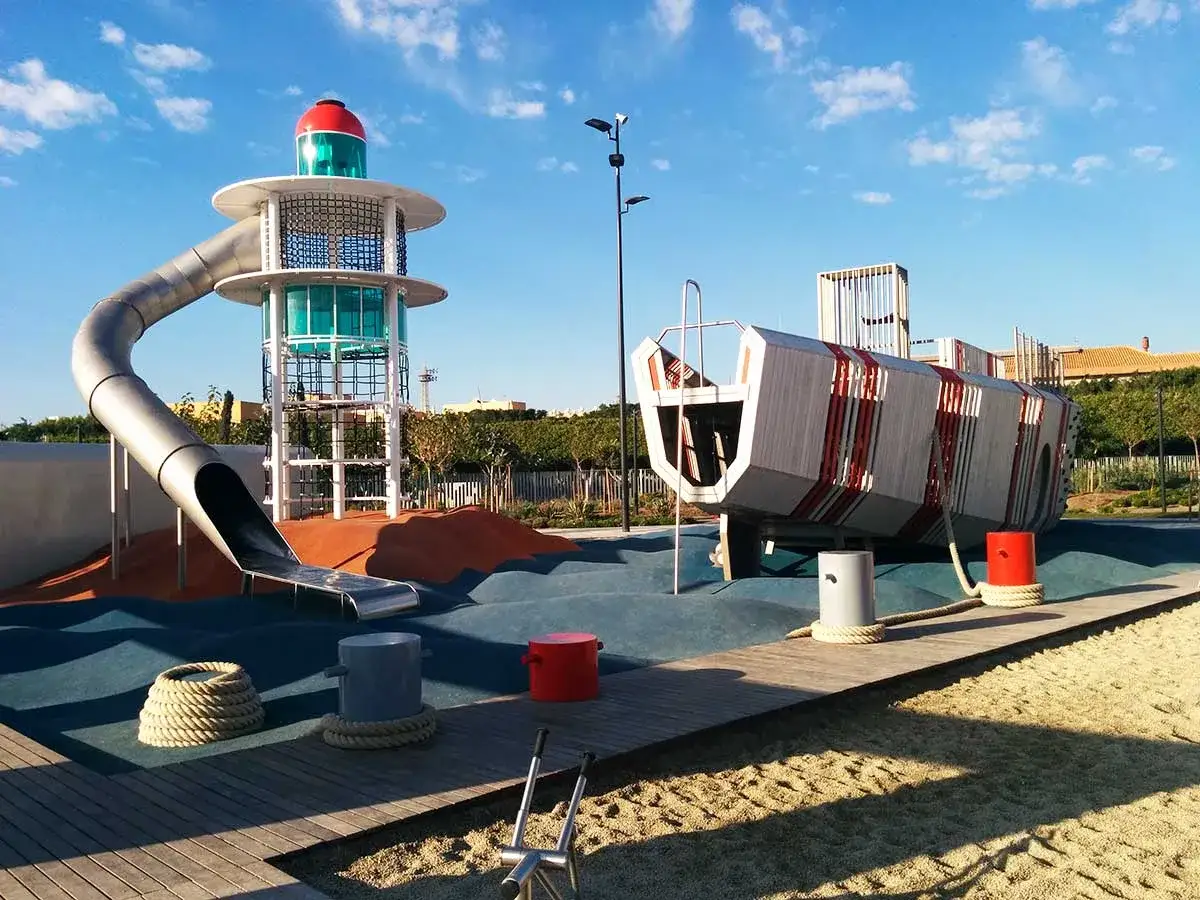 Parque infantil temático de barcos y faros en Almería, ideal para familias. Tobogán curvo y estructura de barco invitan a la aventura.