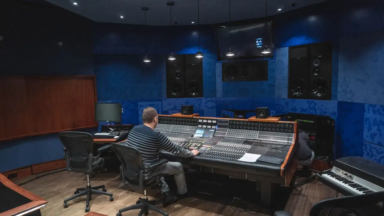Producent muzyczny przy konsoli mikserskiej, dopracowuje miks mastering.