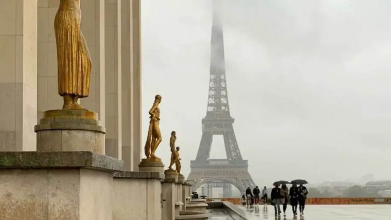 Estatua dorada y la Torre Eiffel, que tipo de estructura es la torre eiffel, en un día nublado.