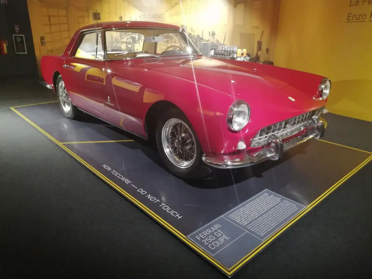 Różowy Ferrari 250 GT Coupe, dzieło Enzo Ferrari, lśni w muzeum. Klasyk z lat 60. na wystawie.
