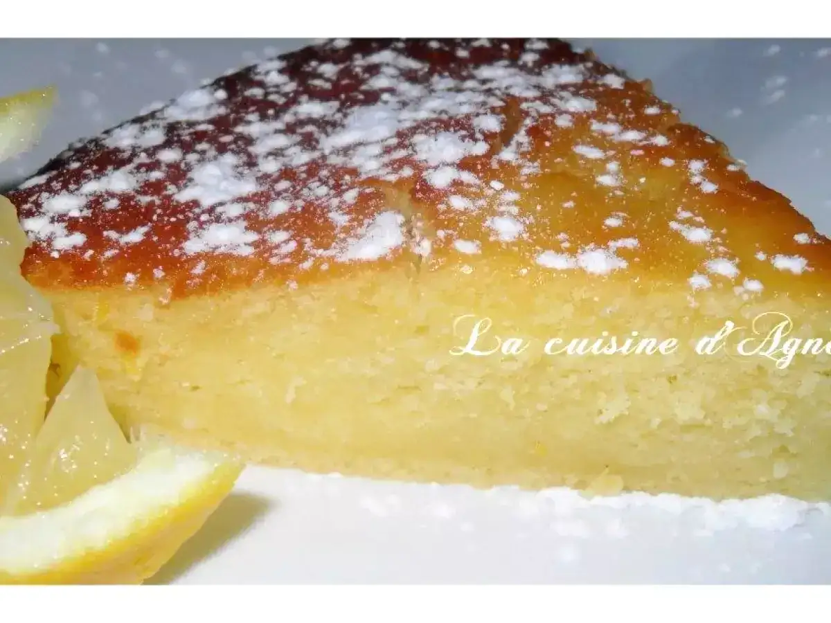 Tranche de g&acirc;teau moelleux, saupoudr&eacute;e de sucre glace, avec des quartiers de citron frais. Une recette g&acirc;teau simple et d&eacute;licieuse.