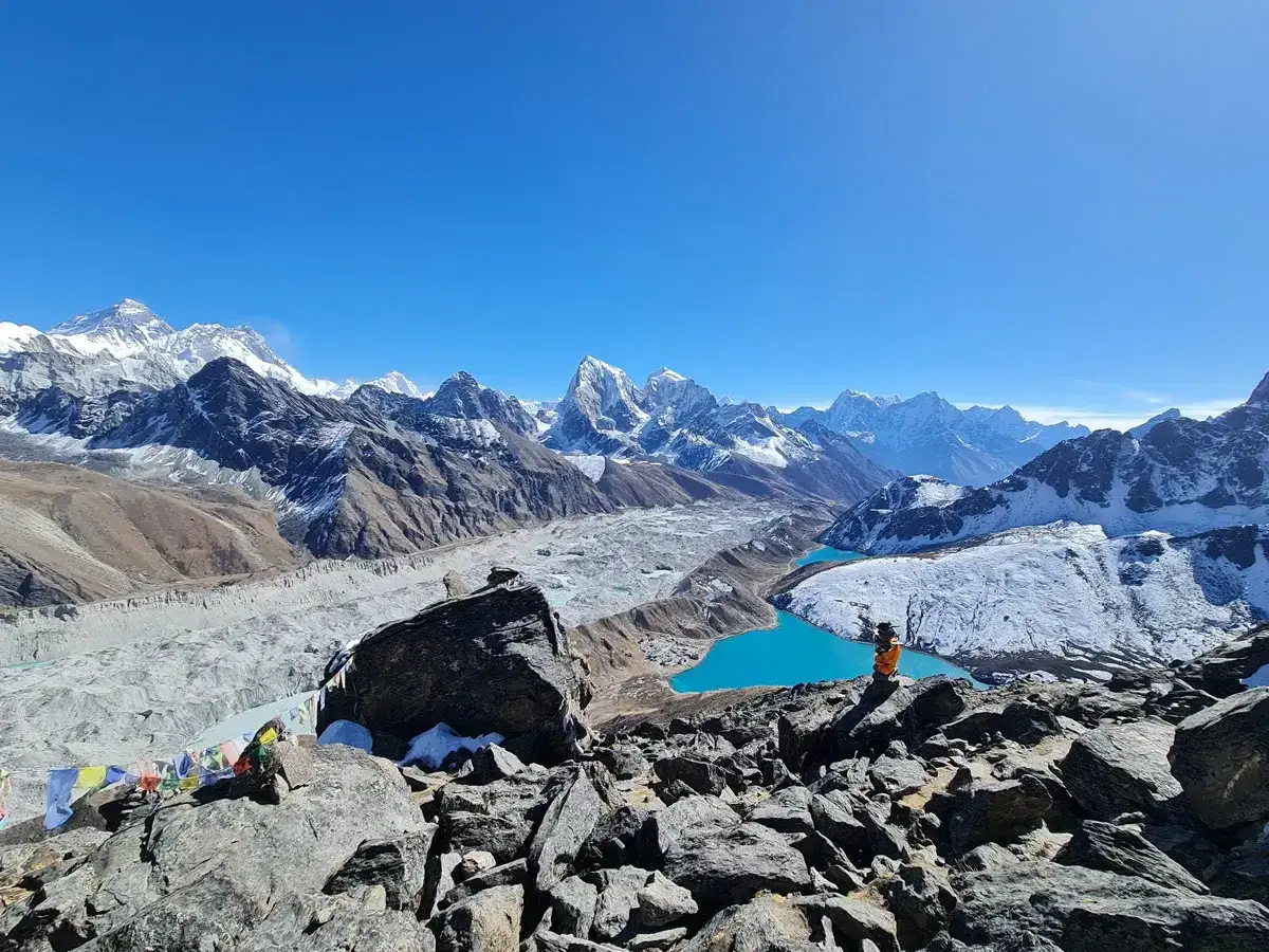 Widok na majestatyczne g&oacute;ry z lodowcem i turkusowymi jeziorami. W oddali widać Everest, cel wyprawy na base camp Everest.