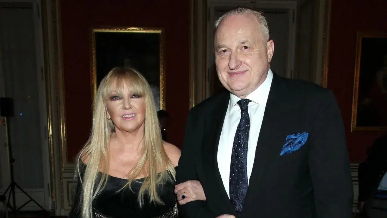 Andrzej Dużyński wiek: elegancka para na wydarzeniu. On w garniturze, ona w czarnej sukni.