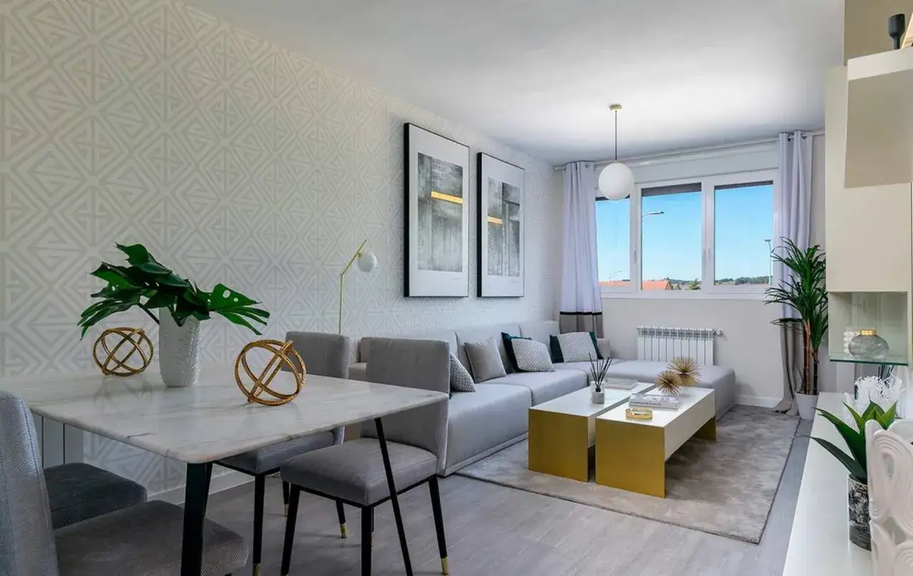 Elegante sal&oacute;n comedor rectangular de 25 metros, con sof&aacute; modular gris, mesa de m&aacute;rmol y decoraci&oacute;n dorada.