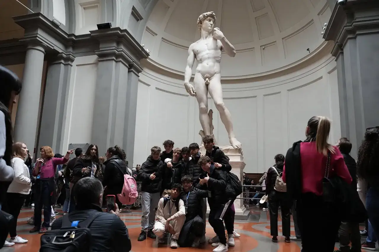La c&eacute;l&egrave;bre statue de David &agrave; Florence, entour&eacute;e de visiteurs admiratifs.