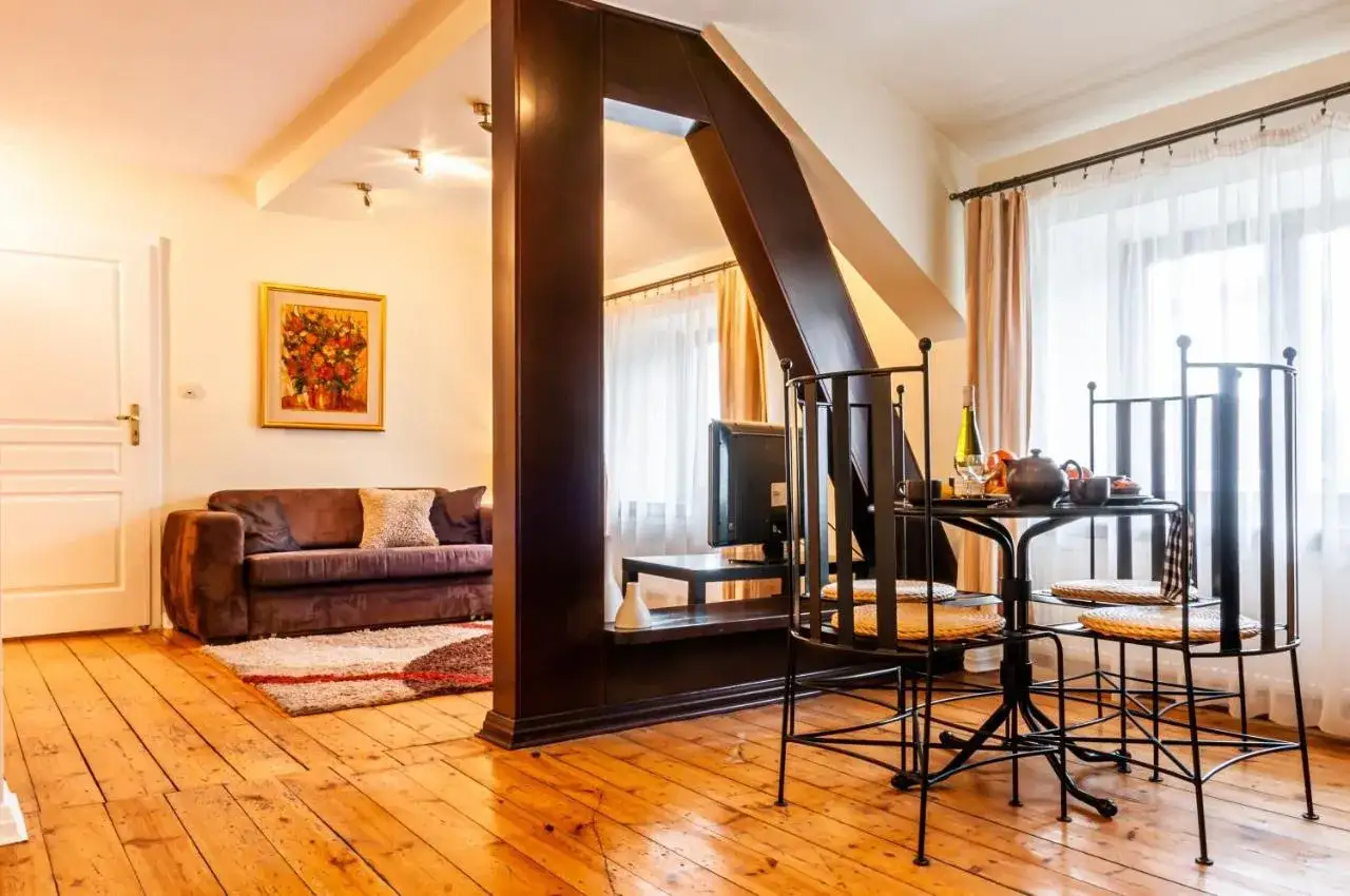 Przytulny pokój w hotelu B&B Łódź: wygodna sofa, stolik z poczęstunkiem i obraz na ścianie.