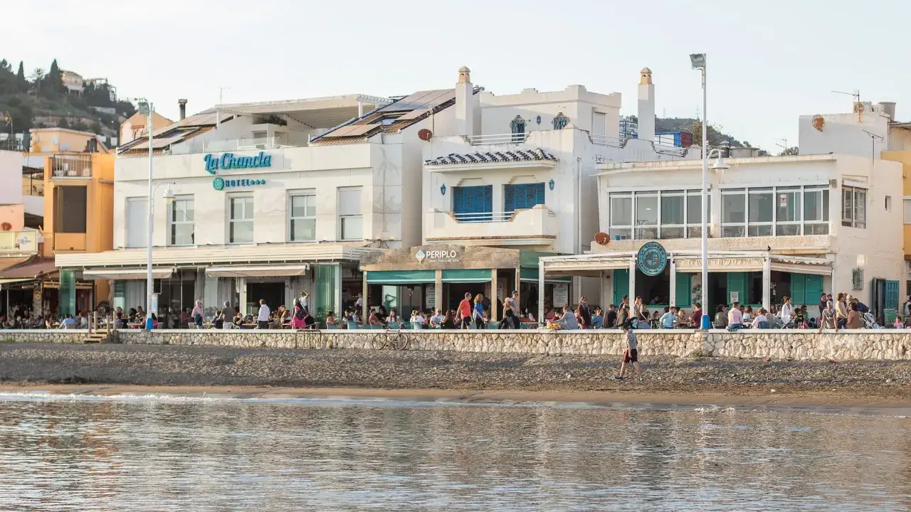 Gente disfrutando en la playa pedregalejo como llegar. Restaurantes y hotel a pie de mar.