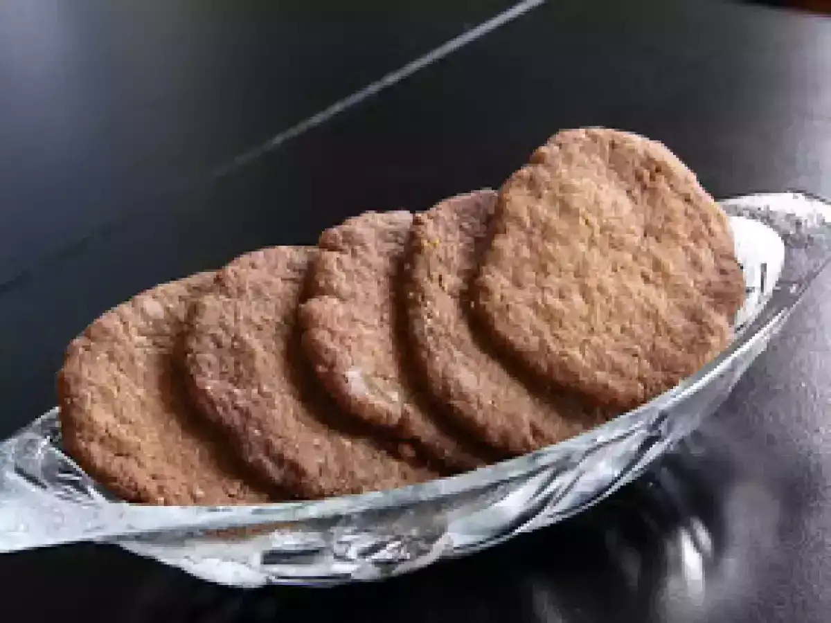 Une assiette en verre remplie de tuiles aux amandes, prêtes à être dégustées.