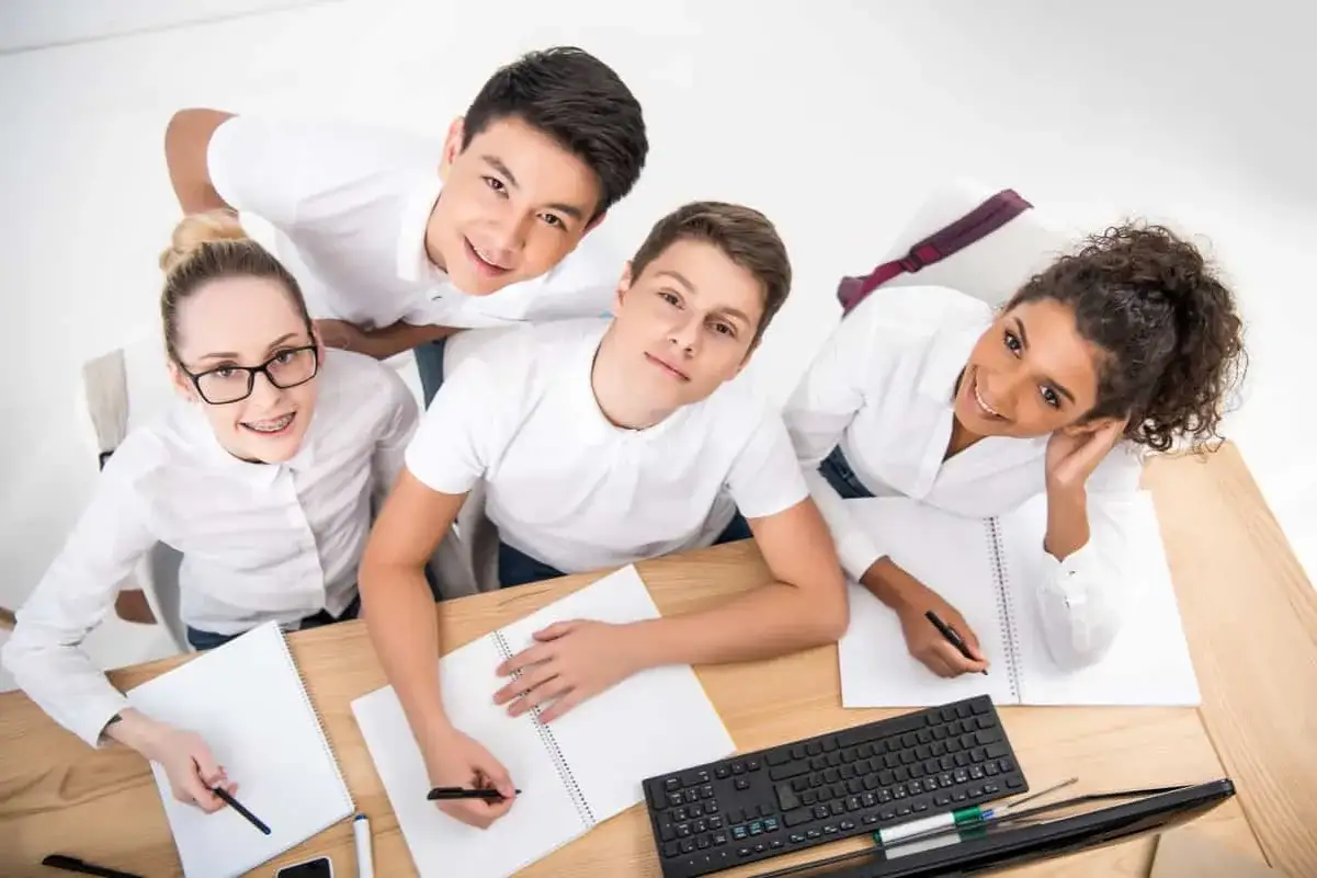 Adolescentes sonrientes participan en ejercicios de escritura creativa, con cuadernos y bol&iacute;grafos listos para plasmar sus ideas.