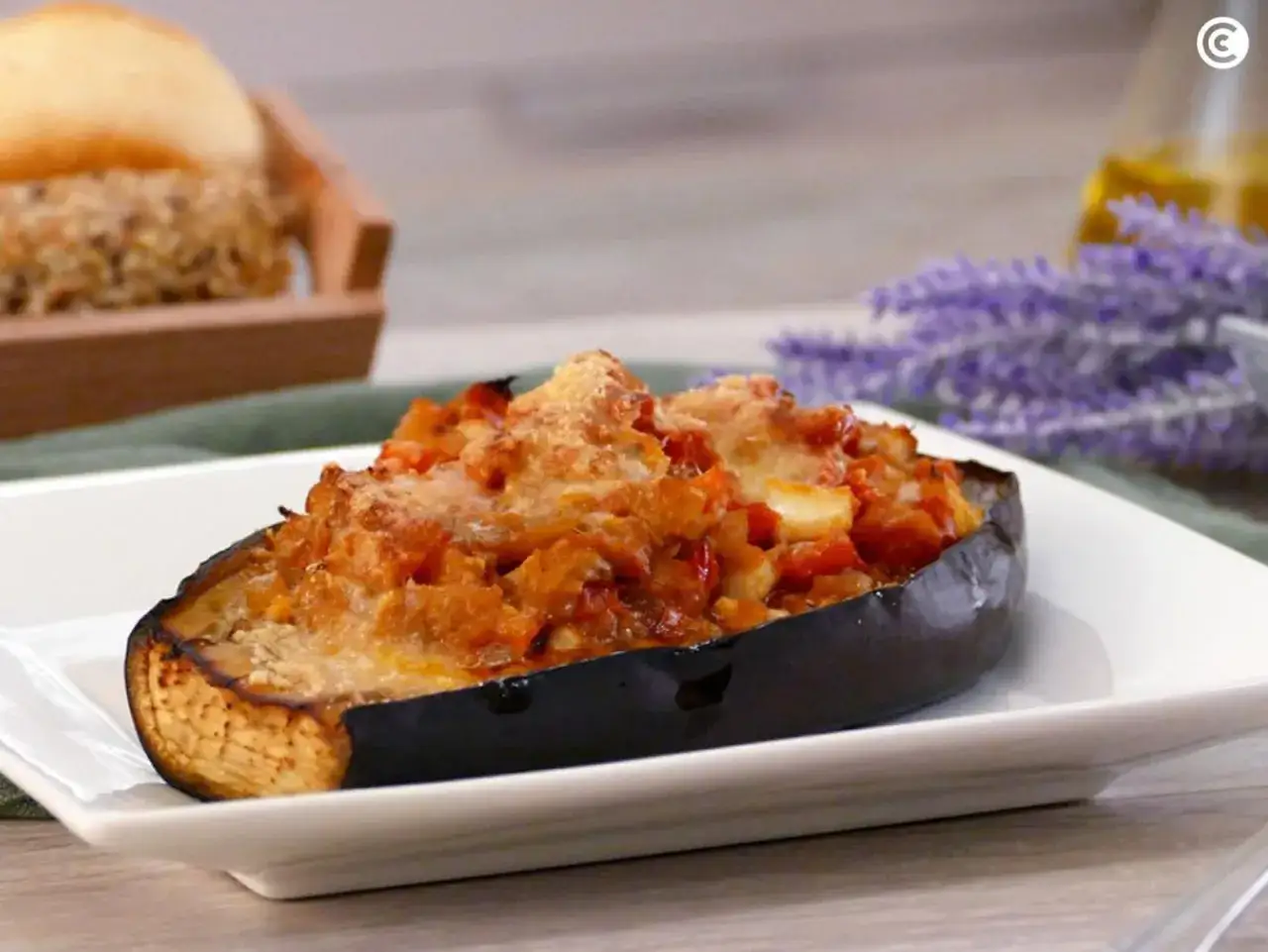 Berenjenas rellenas de atún, gratinadas con queso y acompañadas de un pan rústico.