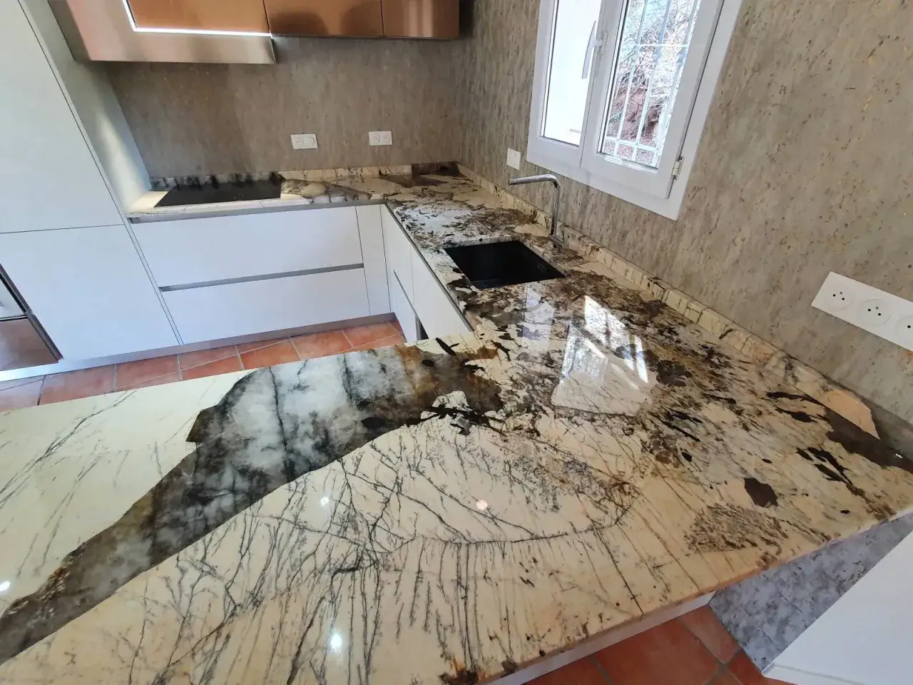 Plan de travail en granit aux motifs saisissants, rappelant des éclairs sur un fond clair. Attention, sa beauté peut être un danger pour les yeux !