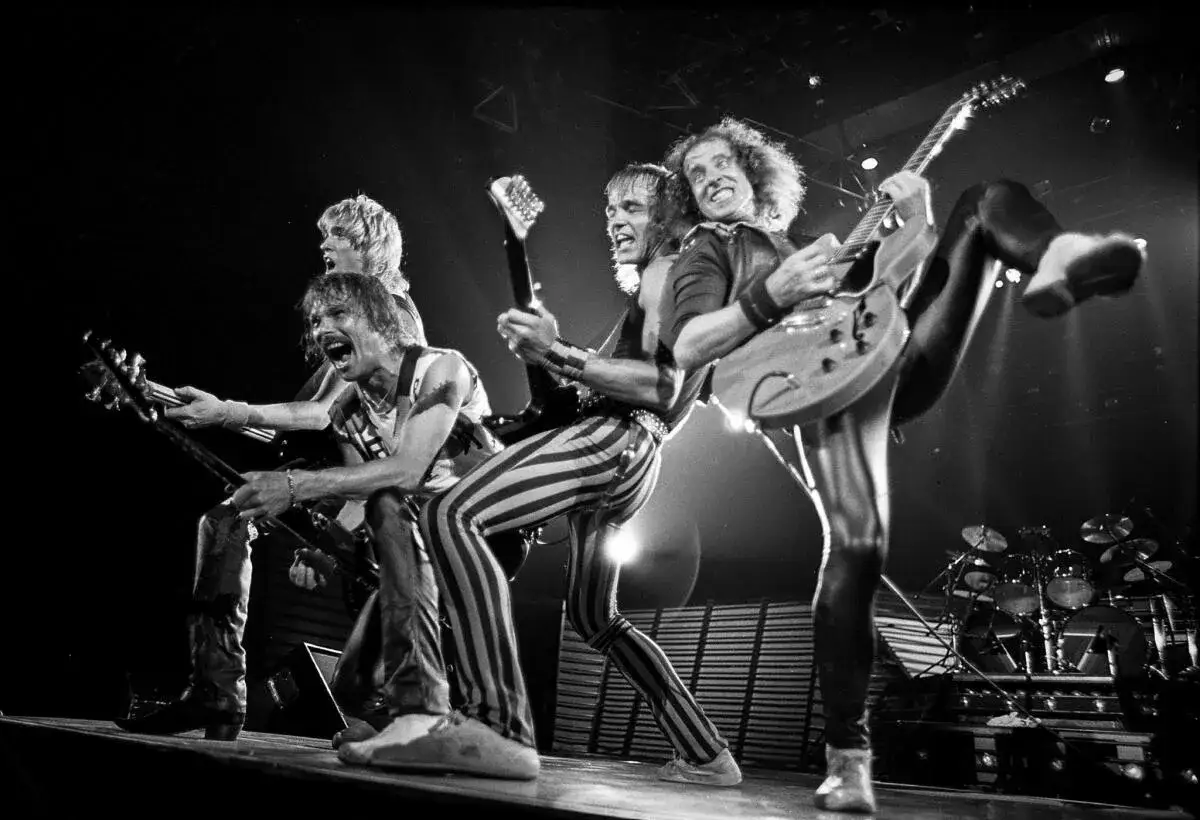 Zespół Scorpions na scenie, grający rockowe ballady. Wokalista krzyczy, gitarzyści szaleją.