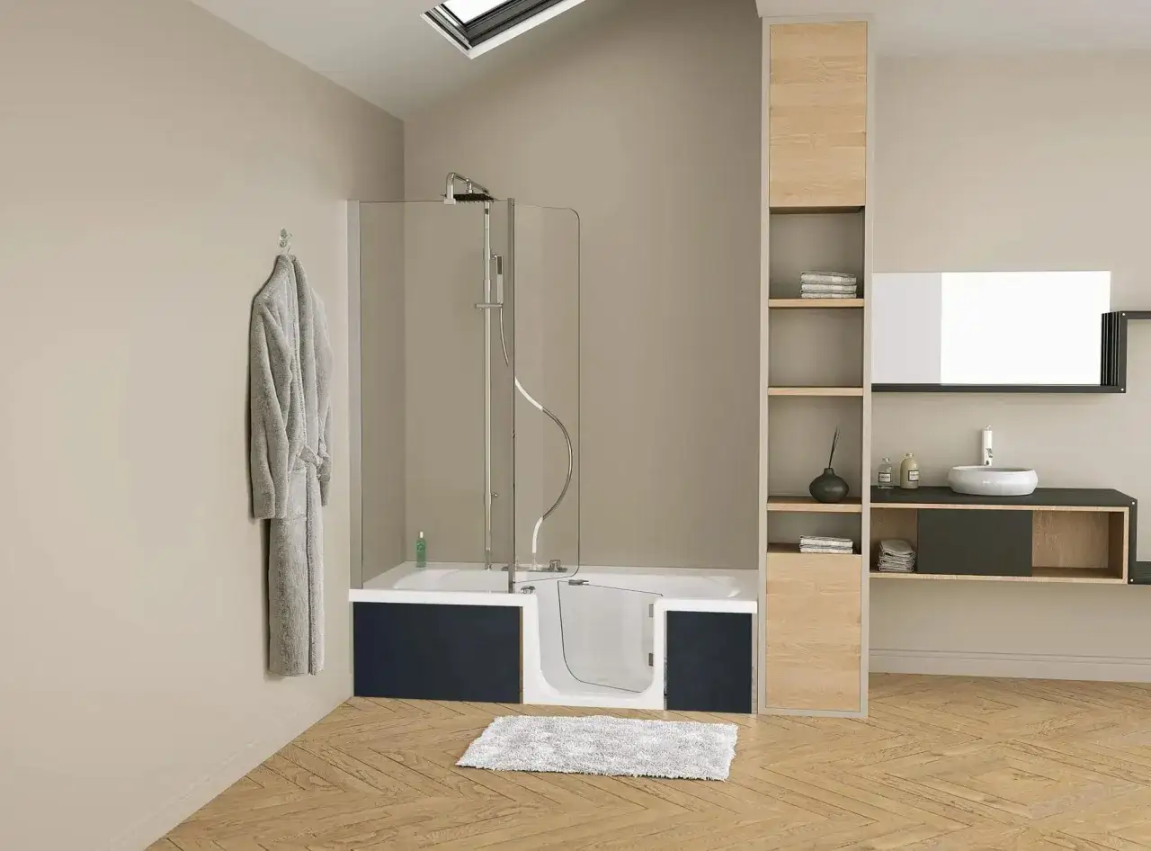 Salle de bain moderne avec une baignoire con&ccedil;ue pour changer facilement en douche, un peignoir gris suspendu et des &eacute;tag&egrave;res en bois.