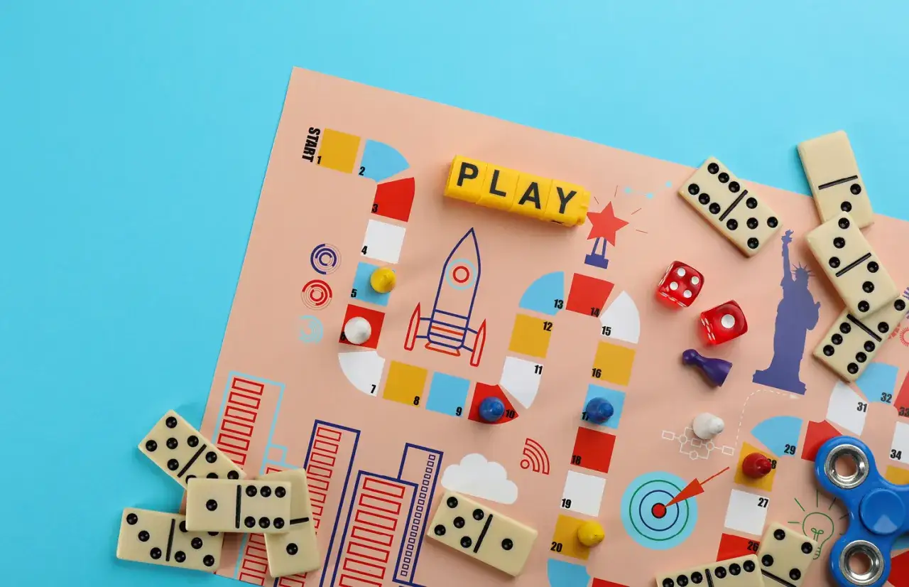 Kolorowa plansza z rakietą i kostkami, idealna do gry dla ośmiolatków. Domino i fidget spinner dodają zabawy.
