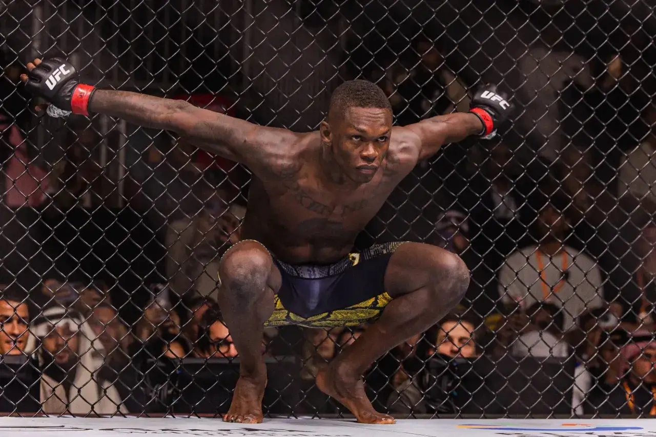 A fighter in UFC gloves crouches low, ready for action. He's a powerful presence, embodying the intensity of flyweight weight class competition.