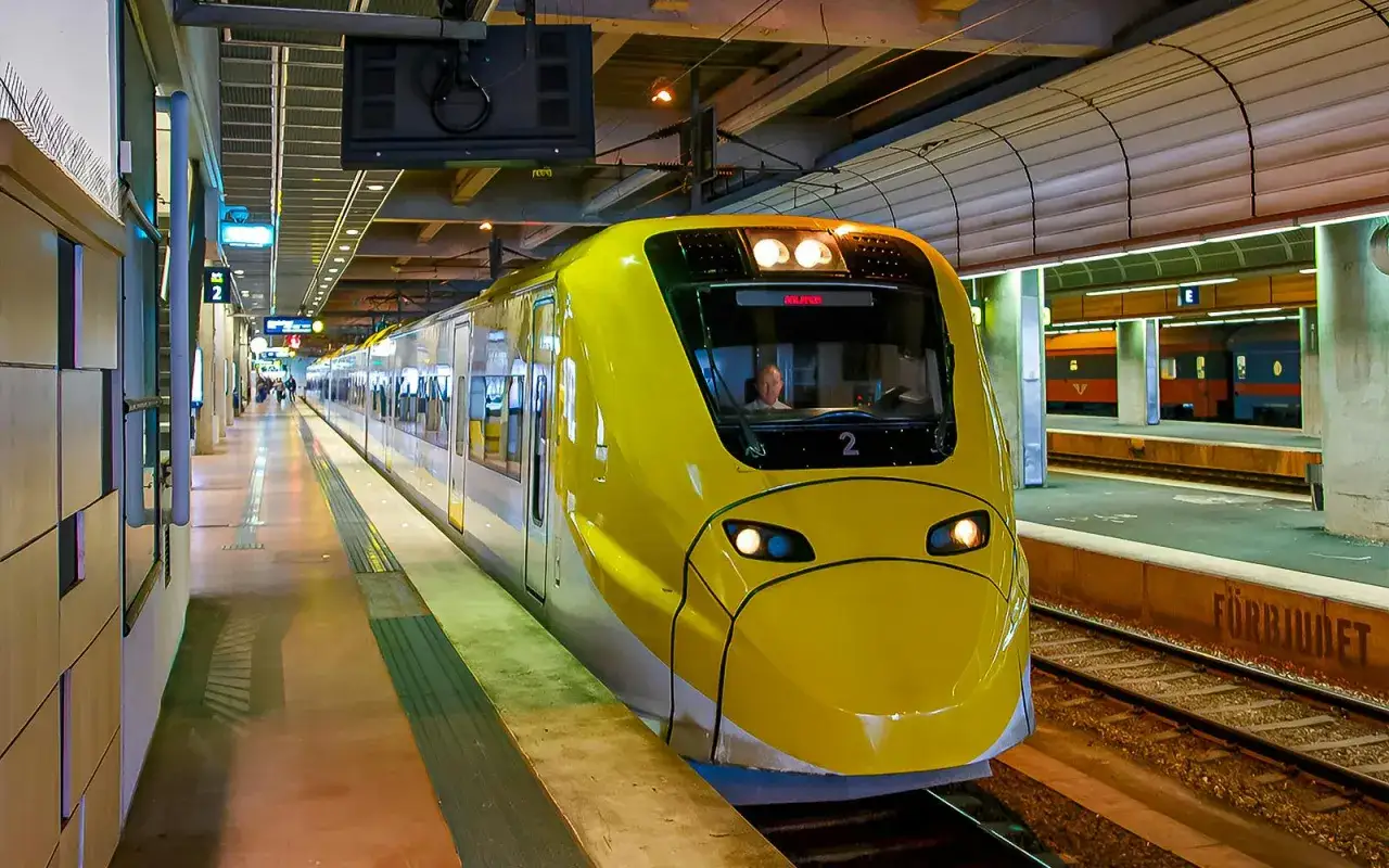 Żółty pociąg Arlanda Express na stacji. Sprawdź arlanda express cena, aby zaplanować podróż.