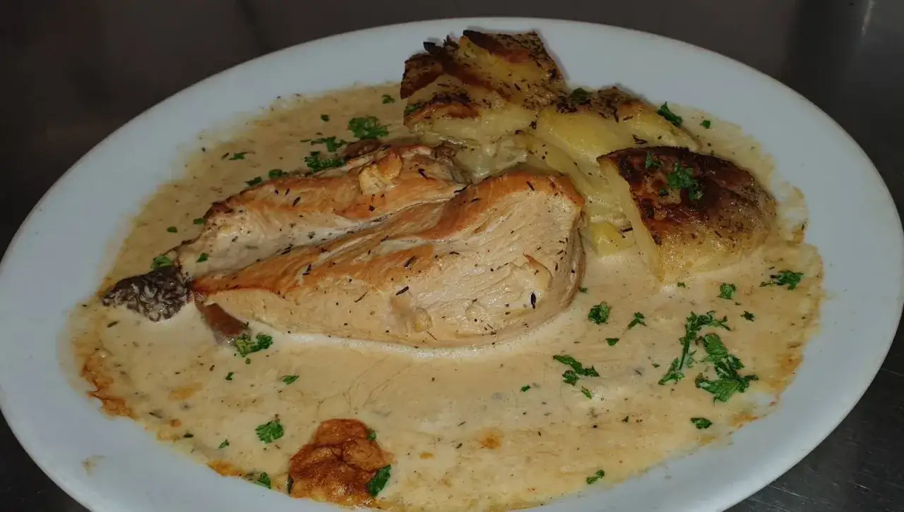 Un plat gourmand de poulet aux morilles &agrave; la cr&egrave;me, servi avec des pommes de terre r&ocirc;ties et parsem&eacute; de persil frais.