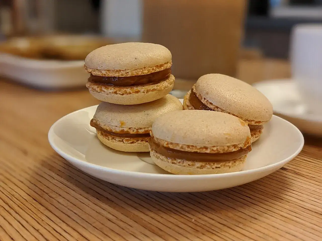 Macarons de dulce de leche en un plato blanco. ¿De donde son los macarons? ¡Parecen deliciosos!