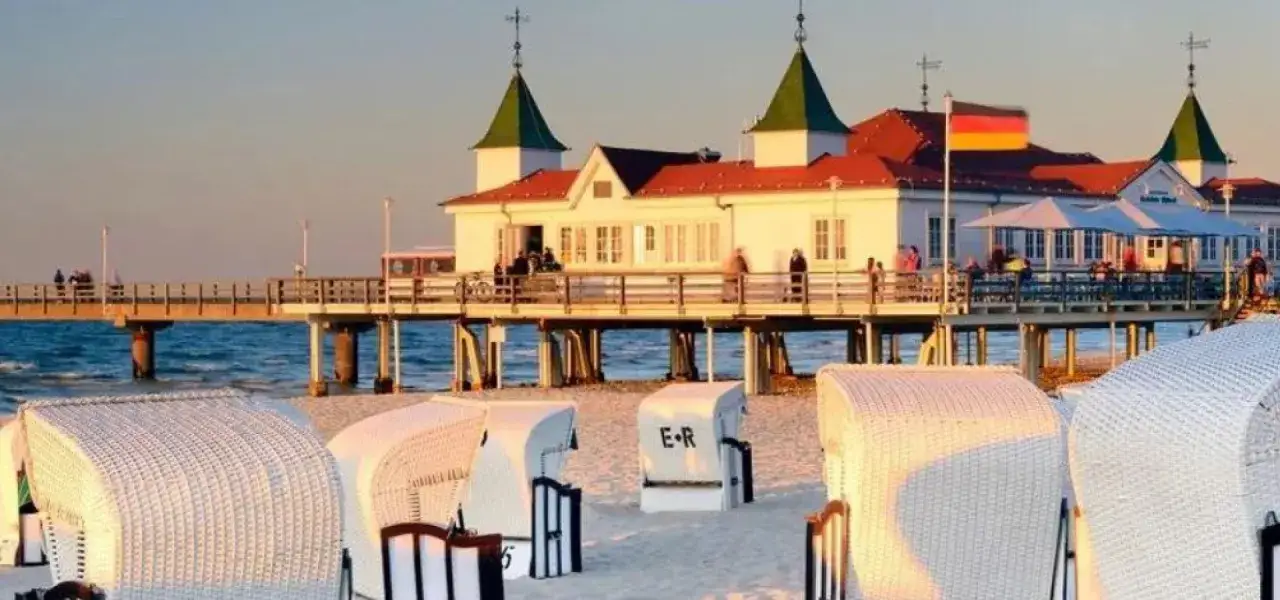 Plaża w Ahlbecku z molo i charakterystycznymi koszami plażowymi. Idealne miejsce na relaks i podziwianie zachodu słońca.