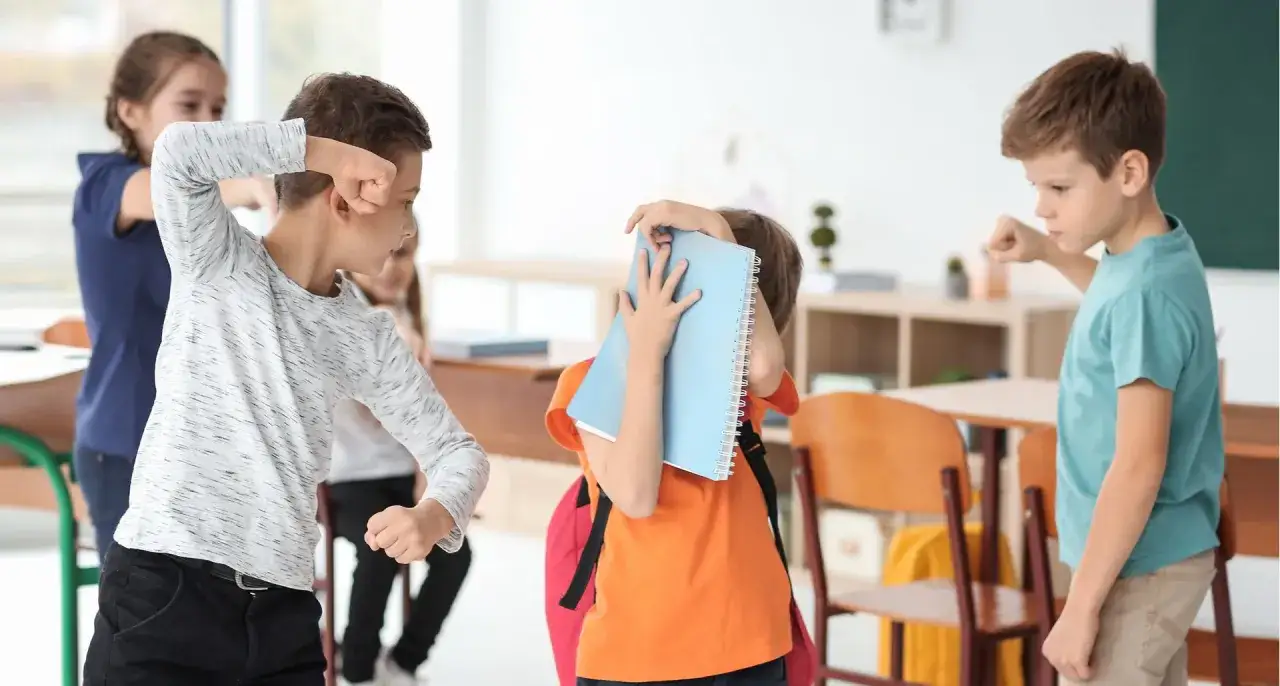 Kinder streiten sich, ein Junge wird von anderen bedrängt. Ein trauriges Beispiel für Mobbing in der Grundschule.